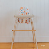Posture & Comfort Kit on an IKEA Antilop highchair: maple footrest, floral cushion cover and support insert