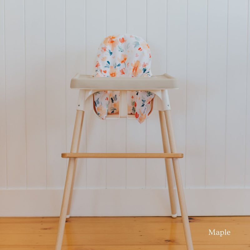 Posture & Comfort Kit on an IKEA Antilop highchair: maple footrest, floral cushion cover and support insert