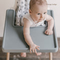 Baby eating from bowl on Little Puku dishwasher-safe silicone placemat fitted to IKEA Antilop highchair