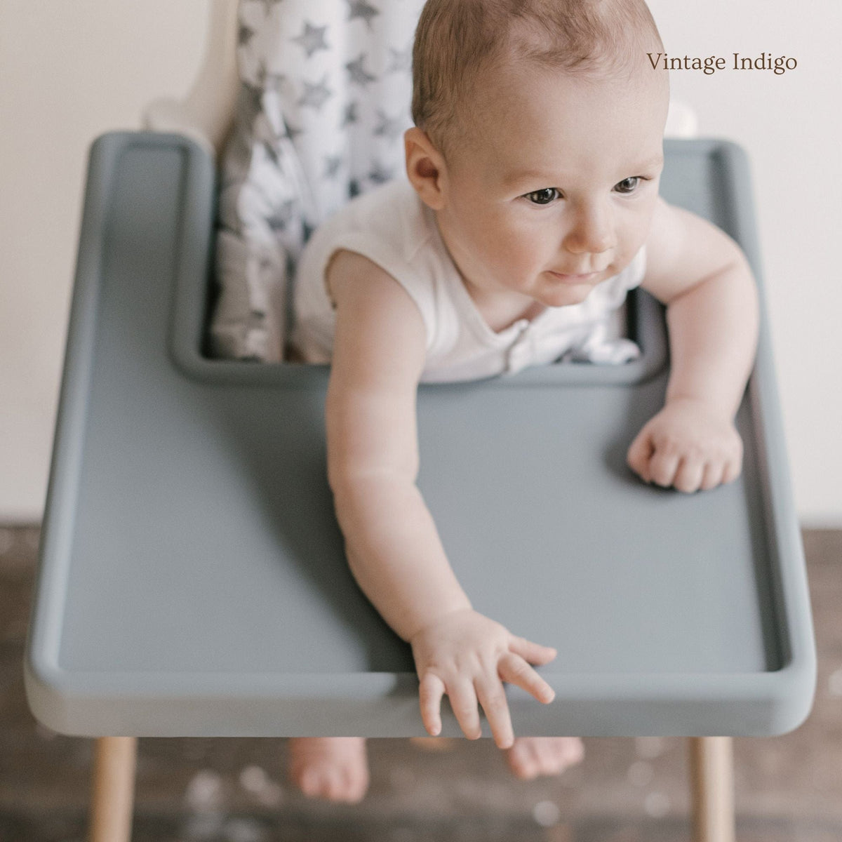 Baby eating from bowl on Little Puku dishwasher-safe silicone placemat fitted to IKEA Antilop highchair